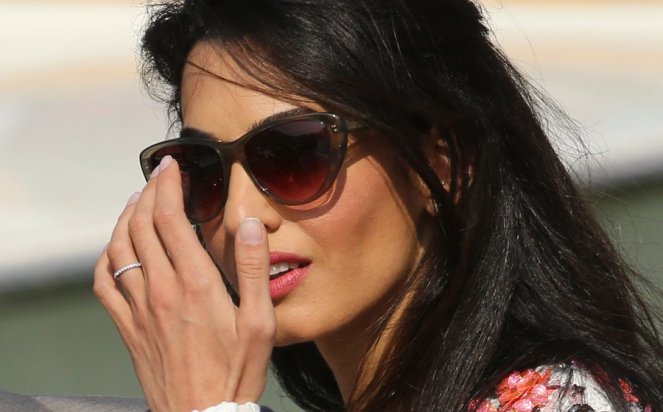 A wedding ring is seen on the hand of Alamuddin as she stands with her husband U.S. actor Clooney in a water taxi on the Grand Canal in Venice